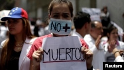 Seorang perempuan membawa tulisan: "Tak ada Lagi Korban Tewas" dalam aksi unjuk rasa pekerja kesehatan menentang Presiden Nicolas Maduro di Caracas, Venezuela, Rabu (17/5).
