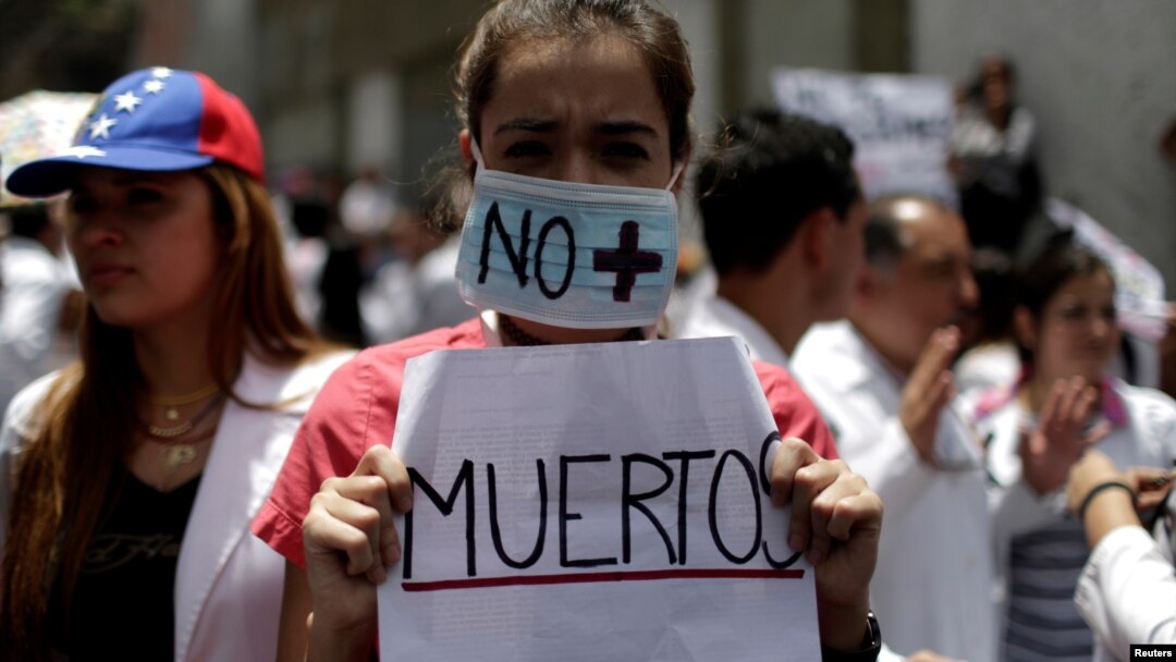 Seorang perempuan membawa tulisan: "Tak ada Lagi Korban Tewas" dalam aksi unjuk rasa pekerja kesehatan menentang Presiden Nicolas Maduro di Caracas, Venezuela, Rabu (17/5).