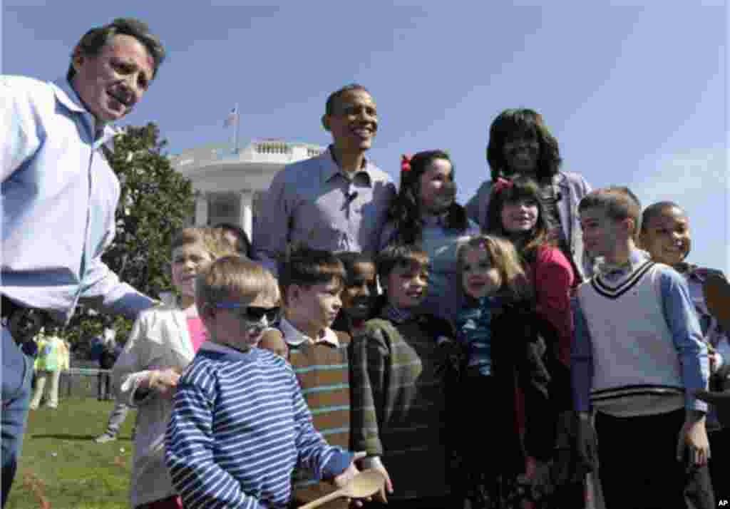 President Barack Obama, first lady Michelle Obama and Neil Heslin, left, whose six-year-old son Jesse Lewis was among the victims of the Newtown School shooting, pose for a photo with participates in the annual Easter Egg Roll on the South Lawn of the Whi