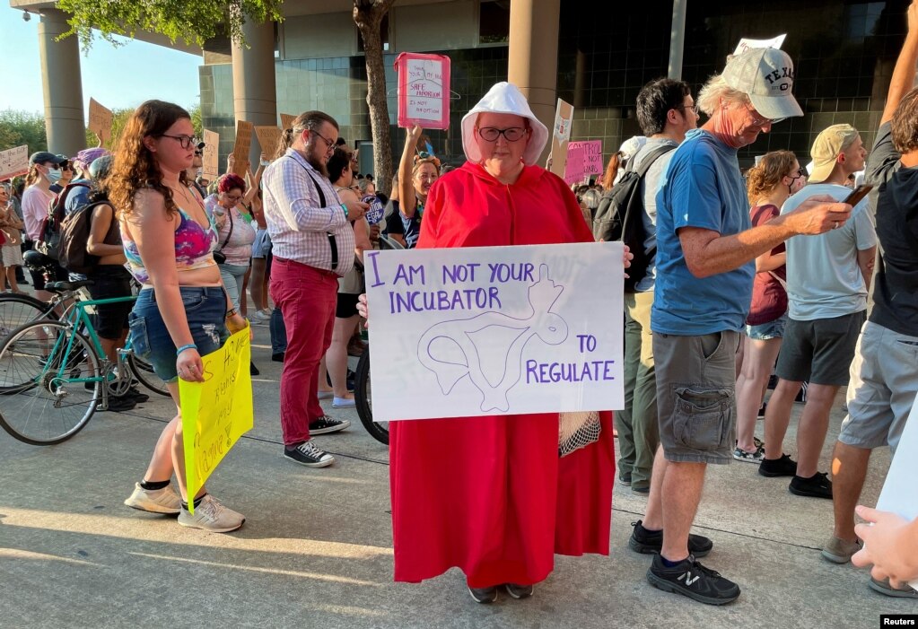 Una manifestante en Houston, Texas, el 24 de junio de 2022, muestra su rechazo al fallo con un cartel que reza: "yo no soy incubadora que puede regular".