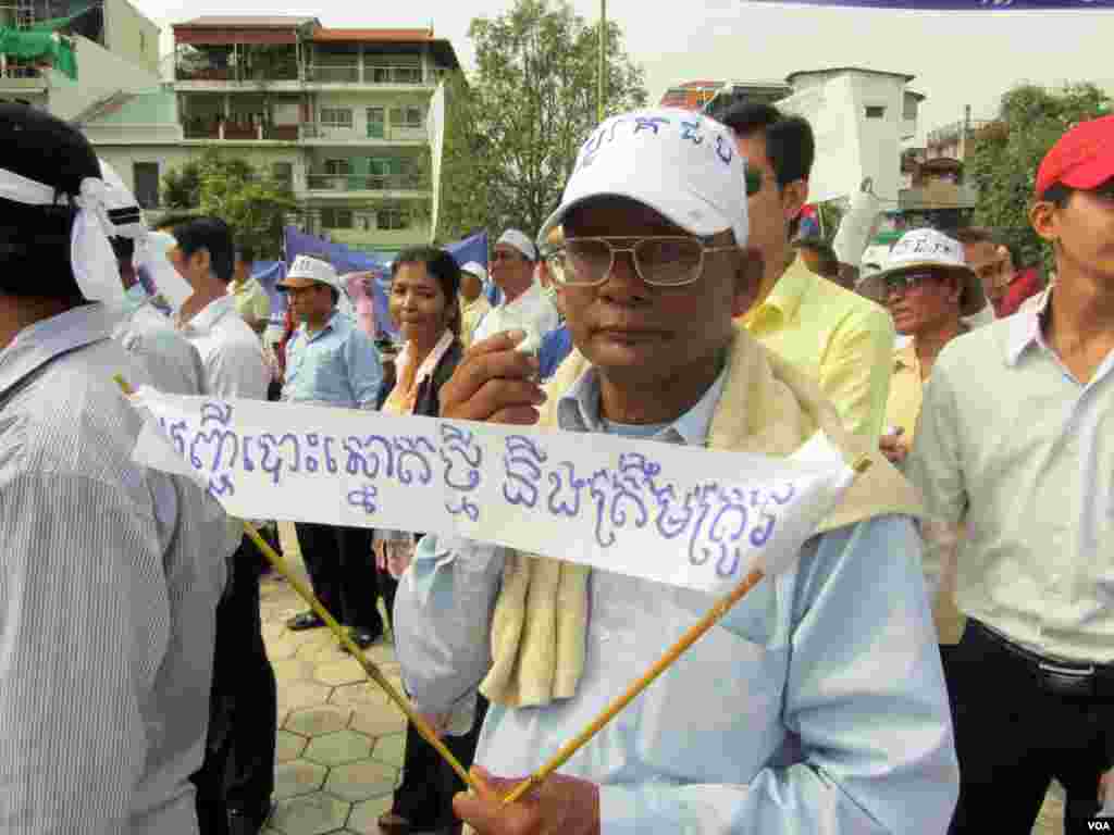 A protester holds a sign reading "The new voters' registration will be accurate." (Heng Reaksmey/VOA Khmer)