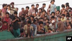 Para migran menunggu di kapal mereka saat menunggu diselamatkan nelayan di Aceh Timur (20/5). (AP/S. Yulinnas)