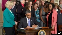 President Barack Obama signs executive actions aimed at closing a compensation gender gap that favors men, Tuesday, April 8, 2014.