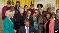FILE - Then-President Barack Obama signs executive actions, with pending Senate legislation, aimed at closing a compensation gender gap that favors men, during an event marking Equal Pay Day in Washington, April 8, 2014. On April 9, in a straight-party-line vote, the Paycheck Fairness Act was blocked by a Republican filibuster in the Senate.