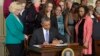 President Barack Obama signs executive actions aimed at closing a compensation gender gap that favors men, Tuesday, April 8, 2014.