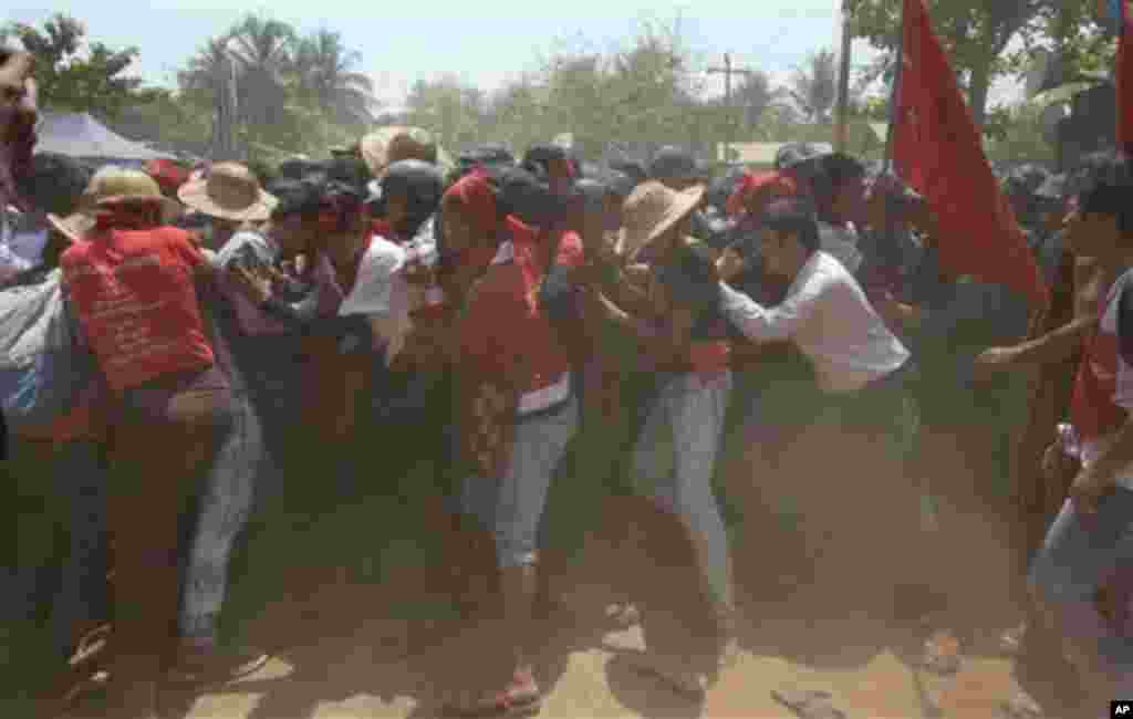 دانشجویان معترض در تلاش برای شکستن سدمعبر پلیس در جریان اعتراضات دانشجویی در لتپادان، میانمار.