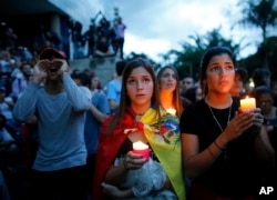 Anti-government demonstrators hold candles during a vigil in honor of those who have been killed during clashes between security forces and demonstrators in Caracas, Venezuela, Monday, July 31, 2017.