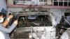 Afghan journalists take a photos of destroyed vehicle inside a house after US drone strike in Kabul, Aug. 29, 2021. 