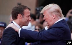 French President Emmanuel Macron (L) meets U.S President Donald Trump during a ceremony to mark the 75th anniversary of D-Day at the Normandy American Cemetery in Colleville-sur-Mer, Normandy, France, June 6, 2019.