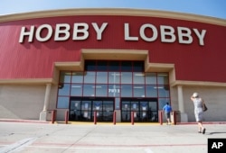 FILE - Customers walk to a Hobby Lobby store in Oklahoma City, June 30, 2014. A Hobby Lobby spokesman told The Associated Press Wednesday that a report that the company was considering going out of business is not true.