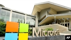 FILE - Microsoft Corp. signage is seen outside the Microsoft Visitor Center in Redmond, Washington, July 3, 2014.