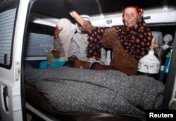 A women mourns over the body Farzana Parveen, who was killed by family members, in an ambulance outside of a morgue in Lahore, May 27, 2014.