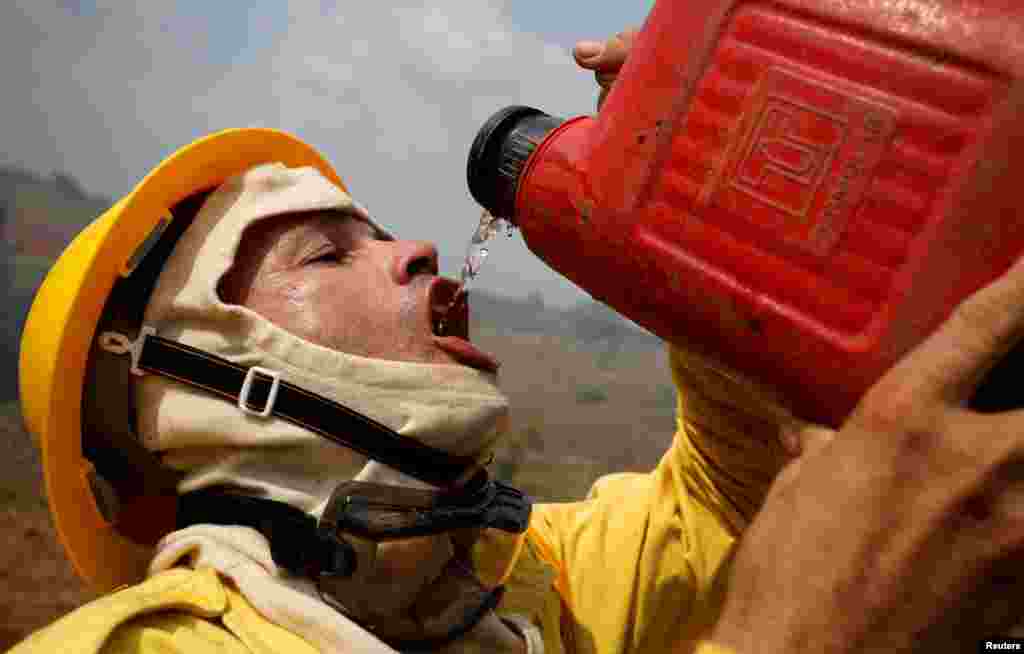 A Brazilian Institute for the Environment and Renewable Natural Resources (IBAMA) fire brigade member drinks water as he attempts to control hot points during a fire in Apui, Amazonas state, Aug. 31, 2019.