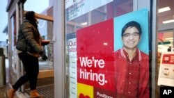 Un letrero en una tienda Target de Westwood, Massachusetts, el 7 de febrero de 2021 anuncia que están contratando a nuevos trabajadores.