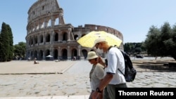 People walk past the Colosseum, amid the outbreak of the coronavirus disease (COVID-19), in Rome, Italy, July 31, 2020. R