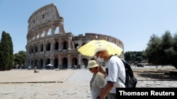 People walk past the Colosseum, amid the outbreak of the coronavirus disease (COVID-19), in Rome, Italy, July 31, 2020. R