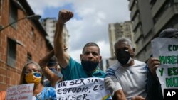 Un hombre grita consignas mientras sostiene una pancarta en una manifestación de maestros en Caracas, el 5 de Octubre de 2020.