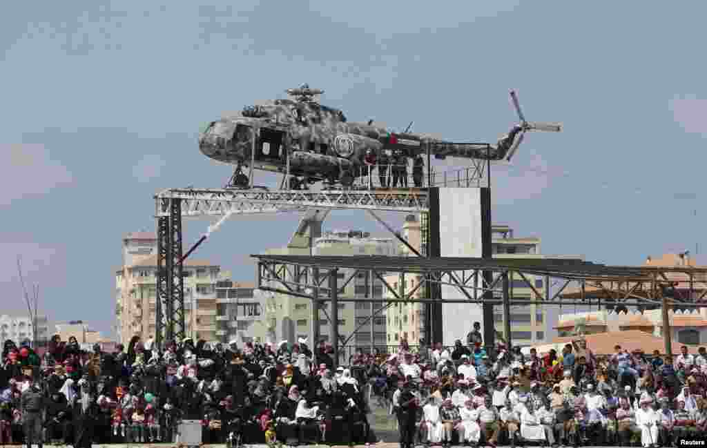 The broken helicopter of late Palestinian President Yasser Arafat is placed on top of a structure as Palestinians watch a military graduation ceremony by policemen loyal to Hamas in Gaza City.