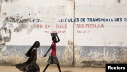 FILE - Girls walk on a road in Maroua, Cameroon, March 17, 2016. 