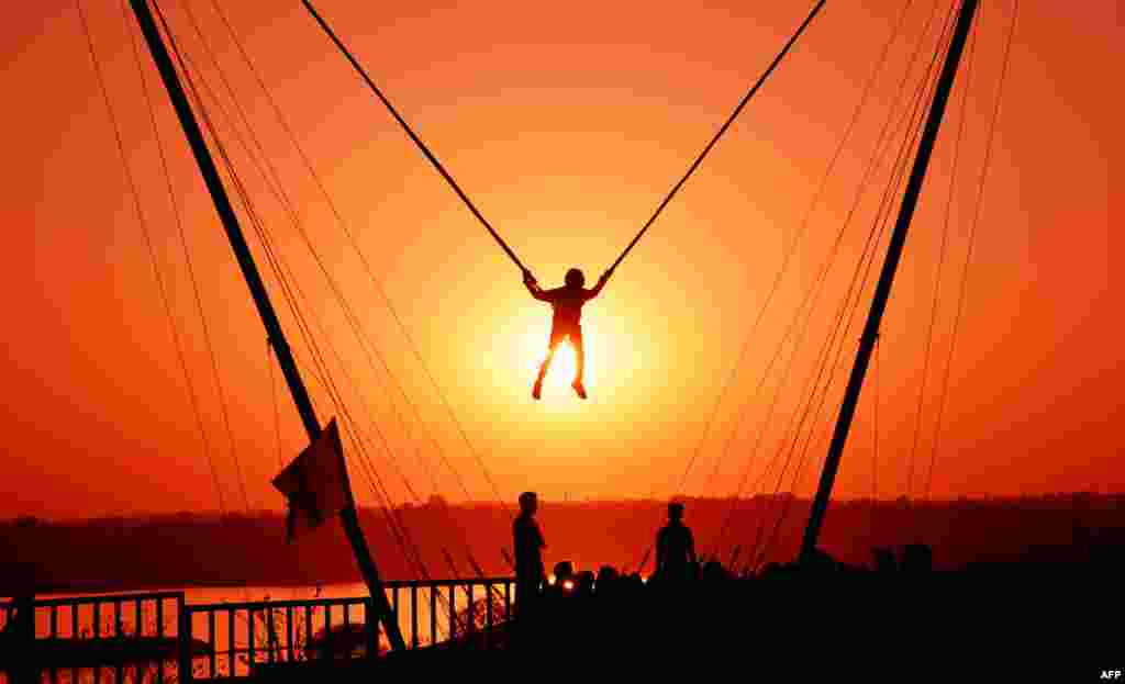An Indian youth takes part in a &#39;bunjee jumping&#39; activity at sunset during the &#39;Bhoj Adventure Festival 2017&#39; in Bhopal, Feb. 25, 2017.
