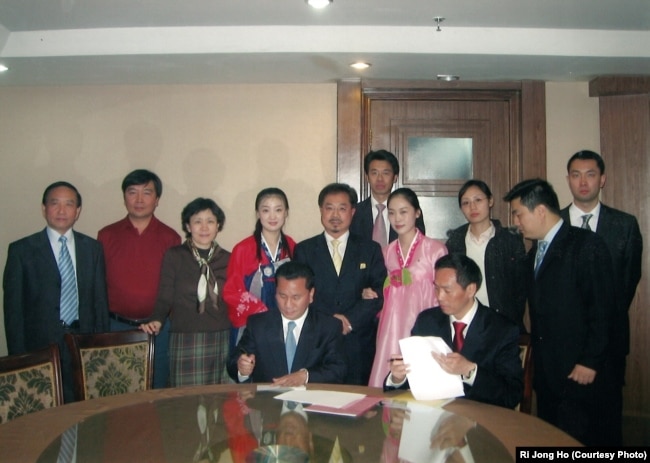 Ri Jong Ho, seated at left, seals a deal on North Korea’s oil exploration with a Hong Kong international oil company in November 2006.