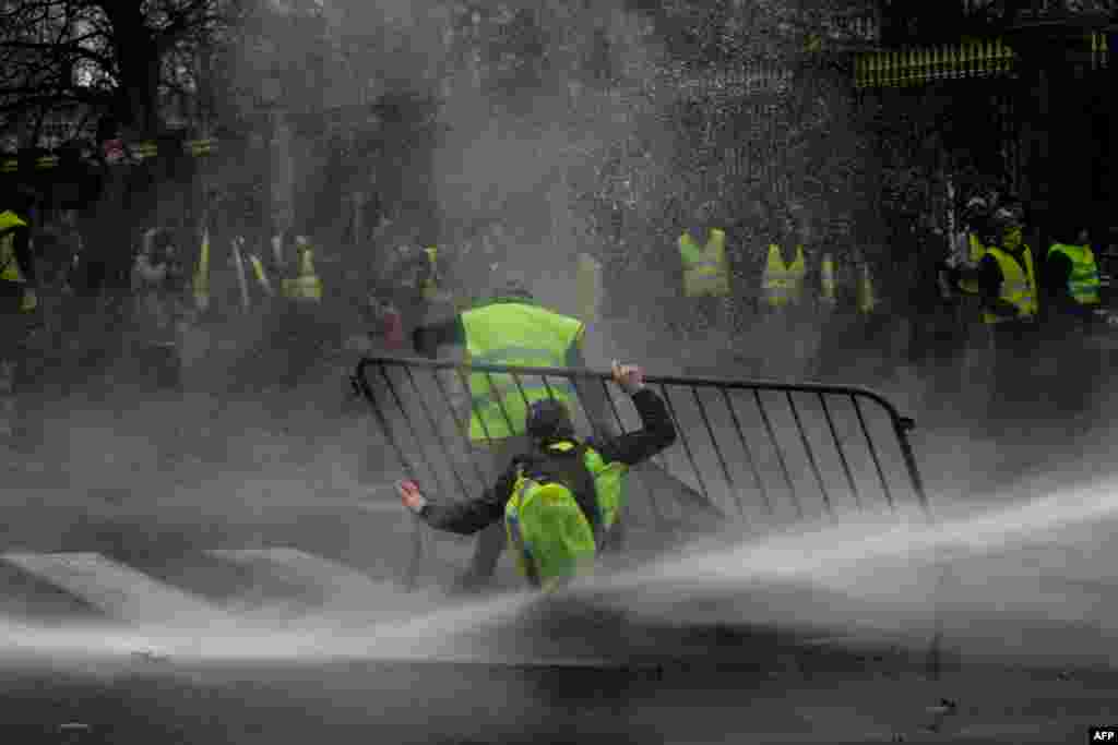 Anti-riot police use a water cannon during clashes with &#39;yellow vest&#39; (Gilet Jaune) protesters during a demonstration, near major EU buildings in Brussels, Belgium.