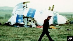 Un oficial de policía camina junto a la nariz del vuelo 103 de Pan Am en un campo cerca de la ciudad de Lockerbie, Escocia, donde yacía después de que explotara una bomba a bordo el 21 de diciembre de 1988.