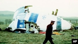 Un policier passe devant l'épave du vol 103 de la Pan Am dans un champ près de la ville de Lockerbie, en Écosse, où il se trouvait après qu'une bombe à bord ait explosé le 21 décembre 1988. (Archives)