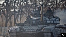 Pemberontak pro-Rusia mengendarai tank di luar Luhansk, Ukraina, 21 Februari 2015. 