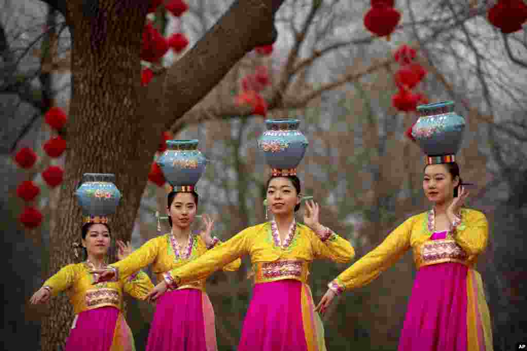Dancers in traditional ethnic clothing perform at a temple fair at Longtan Park in Beijing, China. Chinese people are celebrating the second day of the Lunar New Year, the Year of the Pig on the Chinese zodiac.