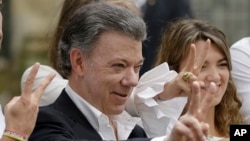 Colombia's President Juan Manuel Santos makes the victory sign after voting in a referendum to decide whether or not to support the peace deal he signed with rebels of the Revolutionary Armed Forces of Colombia, FARC, in Bogota, Colombia, Oct. 2, 2016. 