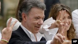 FILE - Colombia's President Juan Manuel Santos makes the victory sign after voting in a referendum to decide whether or not to support the peace deal he signed with rebels of the Revolutionary Armed Forces of Colombia, FARC, in Bogota, Colombia, Oct. 2, 2016. 