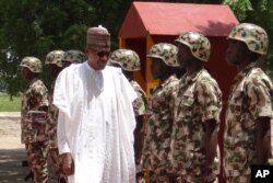 FILE - Nigerian President Muhammadu Buhari reviews troops in Maiduguri on Oct. 1, 2017.