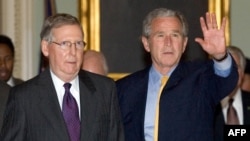 FILE - U.S. President George W. Bush walks with Senate Minority Leader Mitch McConnell after arriving at the Capitol for talks on an immigration reform bill in Washington, June 12, 2007. First elected in 1984, McConnell announced on Feb. 20, 2025, he would retire from the Senate.