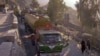 Drivers walk past trucks parked along the highway, including those carrying supplies to NATO forces in Afghanistan, after Pakistan's Torkham border was shut down to traffic November 26, 2011. 