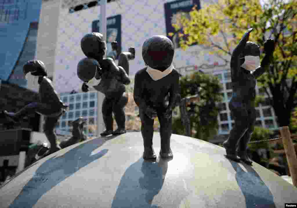 Las estatuas con máscaras protectoras se ven después de que el gobierno anunció el estado de emergencia de la capital, tras el brote de la enfermedad, en el distrito de compras y entretenimiento de Shibuya en Tokio, Japón, el 8 de abril de 2020.