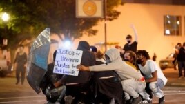 People huddle as they are struck by pepper-balls fired by police during a protest against the deaths of Breonna Taylor by Louisville police and George Floyd by Minneapolis police, in Louisville, Kentucky, U.S. May 29, 2020. (REUTERS/Bryan Woolston)