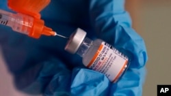 Seorang petugas kesehatan menyiapkan dosis vaksin COVID-19 Pfizer yang disiapkan untuk anak-anak di sebuah klinik vaksinasi di Lawrence, Massachusetts, pada 29 Desember 2021. (Foto: AP/Charles Krupa)