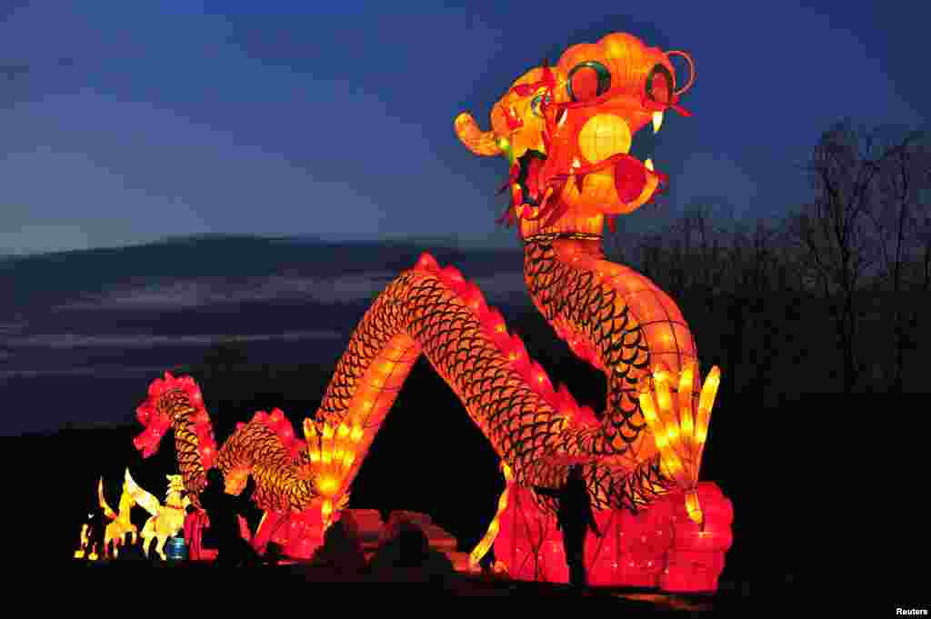 Tourists take a picture in front of a giant dragon lantern during a lantern festival in Shenyang, Liaoning Province, China.
