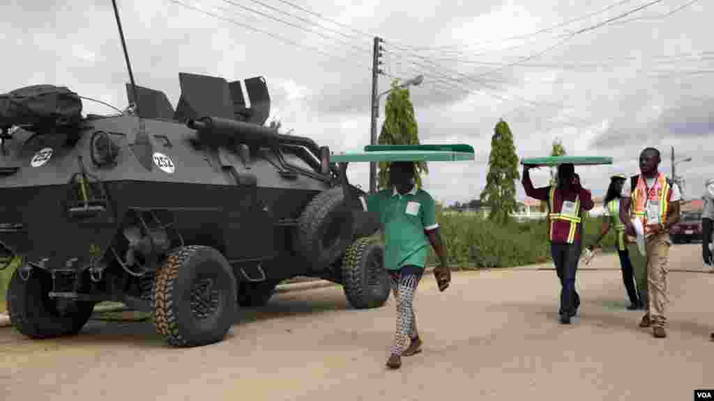 Des agents de la Commission électorale nationale indépendante transportent sur la tête du matériel électoral sous haute sécurité des chars de l&rsquo;armée aux bureaux de vote d&rsquo;Otuoke, dans l&#39;État de Bayelsa samedi 28 mars 2015.