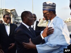 Ivory Coast's President Alassane Ouattara, left, welcomes Nigeria's President Muhammadu Buhari upon arrival at the Felix Houphouet- Boigny airport in Abidjan on Nov. 28, 2017, ahead of the African Union-European Union summit.