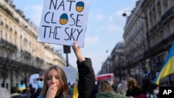 Жінка тримає постер із написом "НАТО, закрий небо" під час демонстрації у Парижі, Франція, 5 березня 2022 р. AP Photo/Francois Mori