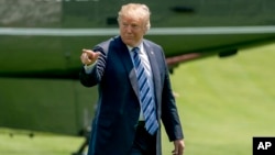 President Donald Trump points to members of the media as he arrives on the South Lawn of the White House in Washington, May 25, 2018. 