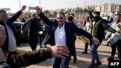 Men just released from prison dance at the entrance of Aleppo city, Dec. 9, 2024, as people wait for the return of relatives after the release of detainees from Syrian government prisons following the ousting of Syria's president.