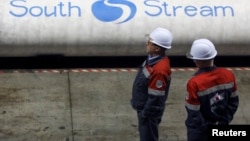 Employees stand near pipes made for the South Stream pipeline at the OMK metal works in Vyksa in the Nizhny Novgorod region, April 15, 2014. 