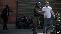 Un manifestante antigubernamental es detenido por las autoridades en Caracas.