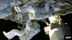 In this still image taken from NASA TV, International Space Station astronauts Chris Cassidy (top) and Tom Marshburn work on repairs to the ISS on May 11, 2013. 