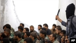 داعش کا جنگجو مغوی شامی فوجیوں کی نگرانی کرتے ہوئے۔ (فائل فوٹو)
