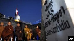 Buddhist monks join supporters of the yellow-shirted People's Alliance for Democracy as they listen to a speech from the stage during a rally near Government House in Bangkok January 28, 2011. Thai "yellow shirt" demonstrators returned to Bangkok's street