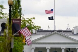 The American flag flies at half-staff over the White House in Washington, April 16, 2021.